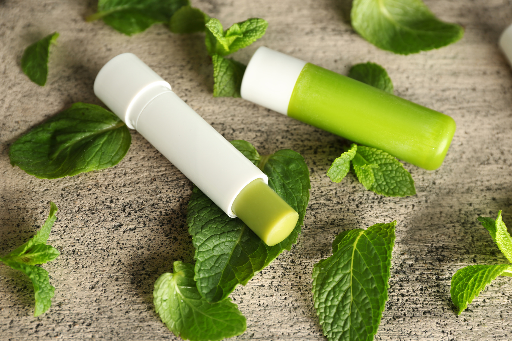 Hygienic Lipstick with Lemon Balm on Textured Background